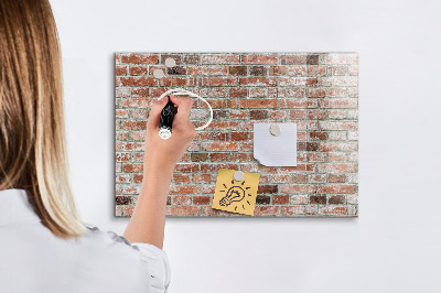 Lavagna magnetica con pennarelli Pannello fotografico su un muro di mattoni
