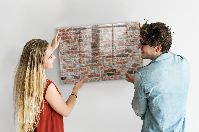 Lavagna magnetica con pennarelli Pannello fotografico su un muro di mattoni